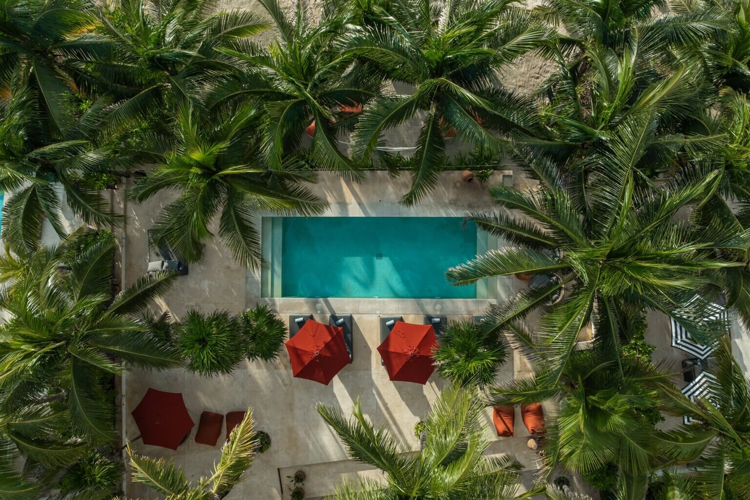 Hacienda Corazón from above: the pool, red umbrellas and palms