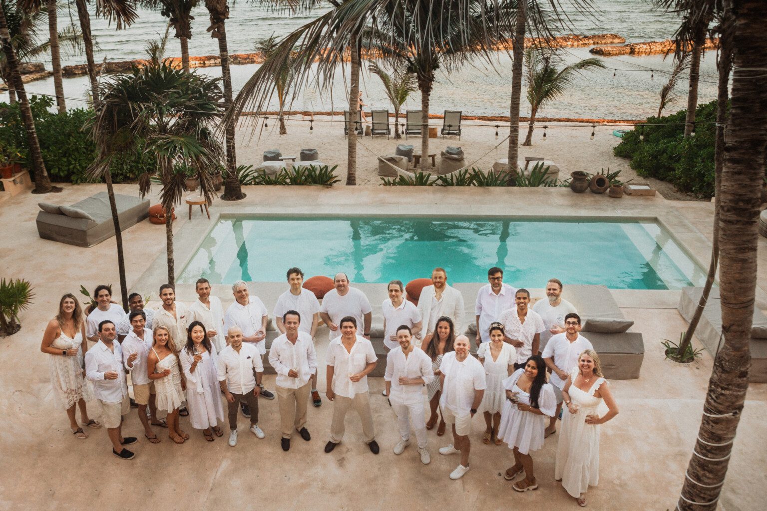 Part of the Riviera Maya Haciendas team, dressed in white, by a hacienda pool