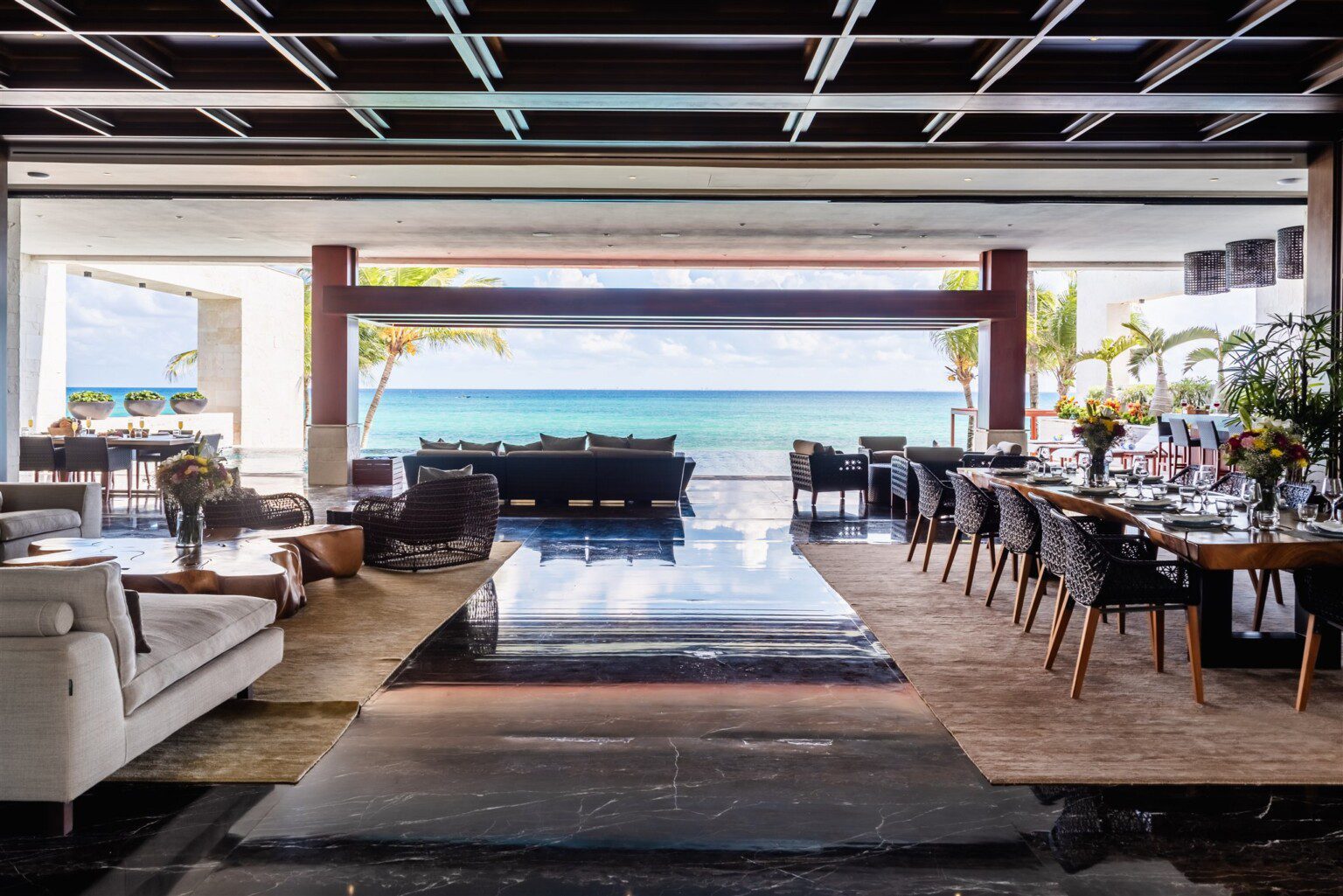 The long dining table and the living room at Casa Nube Blanca, open to the sea