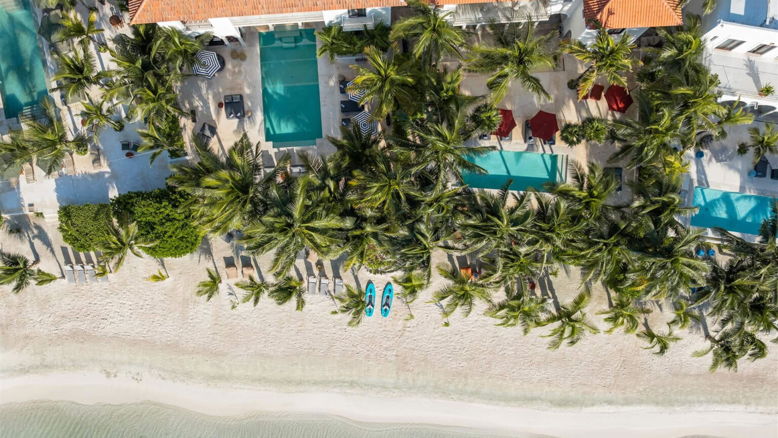 The four haciendas from above: four pools, palms and the beach