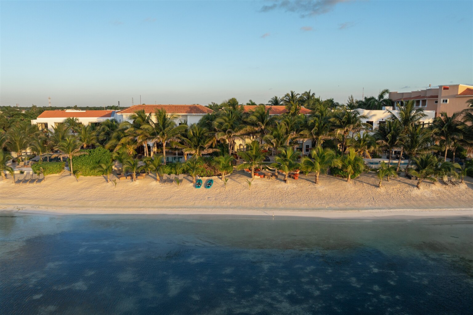 The four haciendas side by side on the beach in Puerto Aventuras, seen from the sea at golden hour