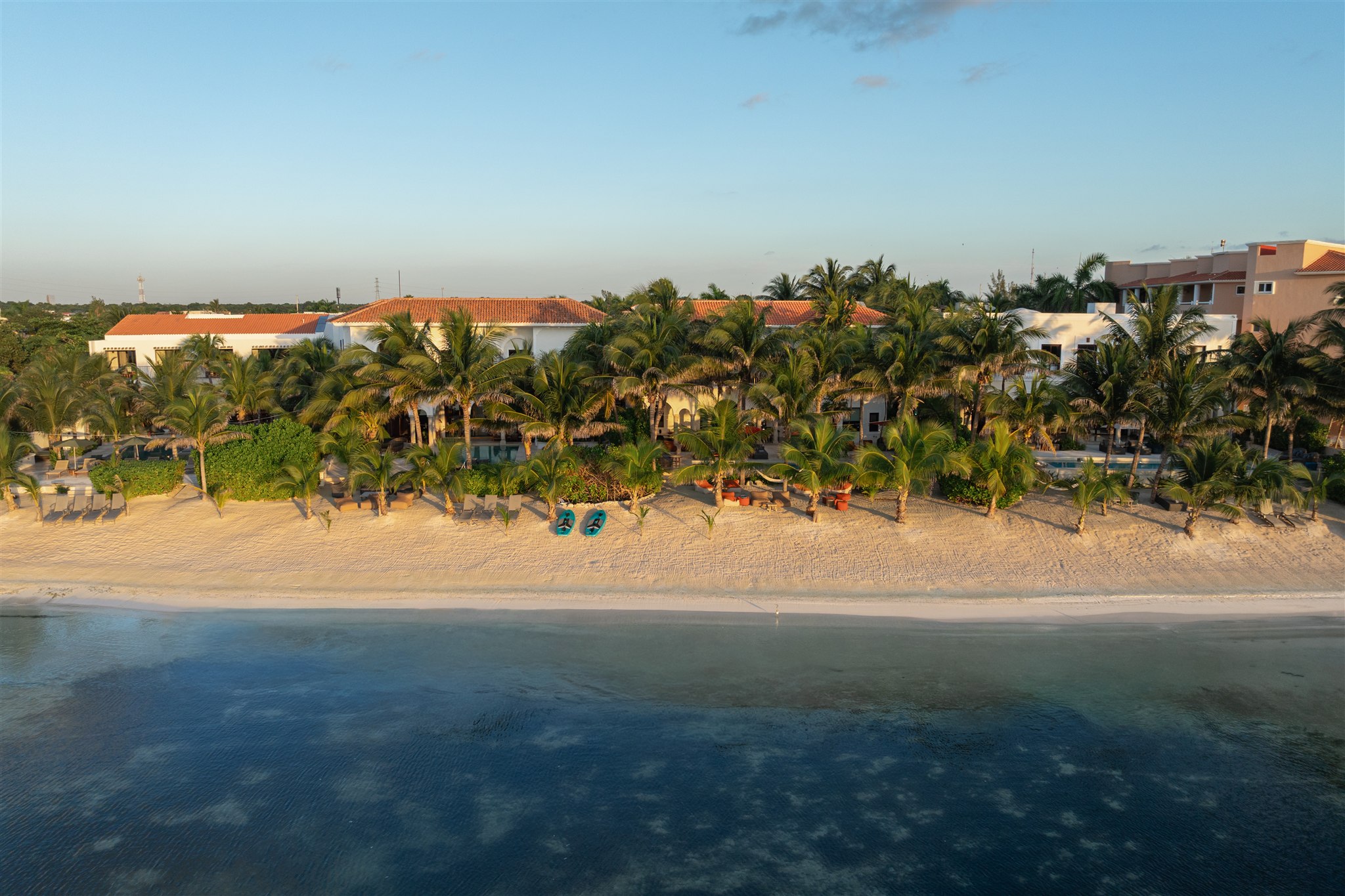 The haciendas side by side on the beach, seen from the sea at golden hour