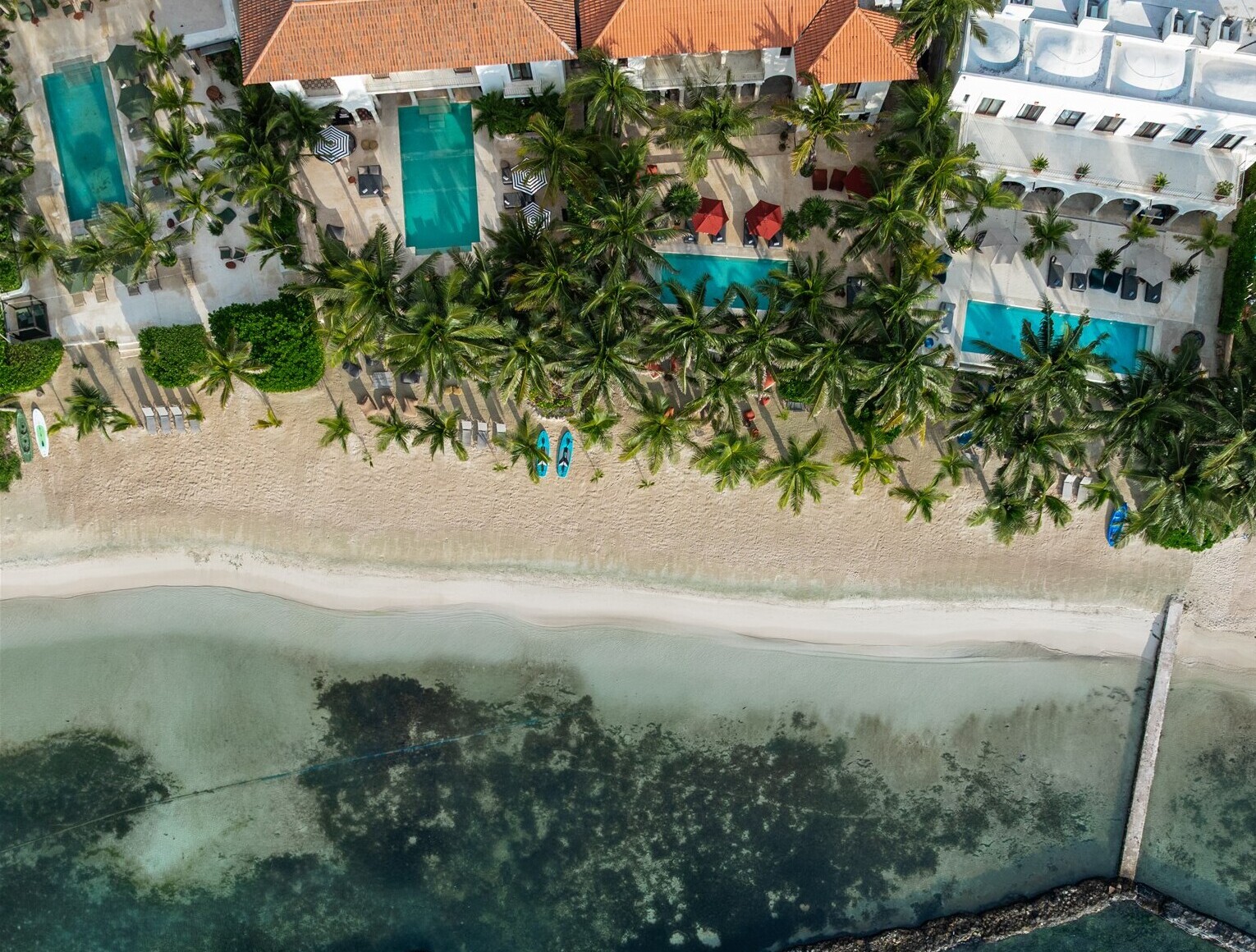 The haciendas and their pools from the air, above the beach