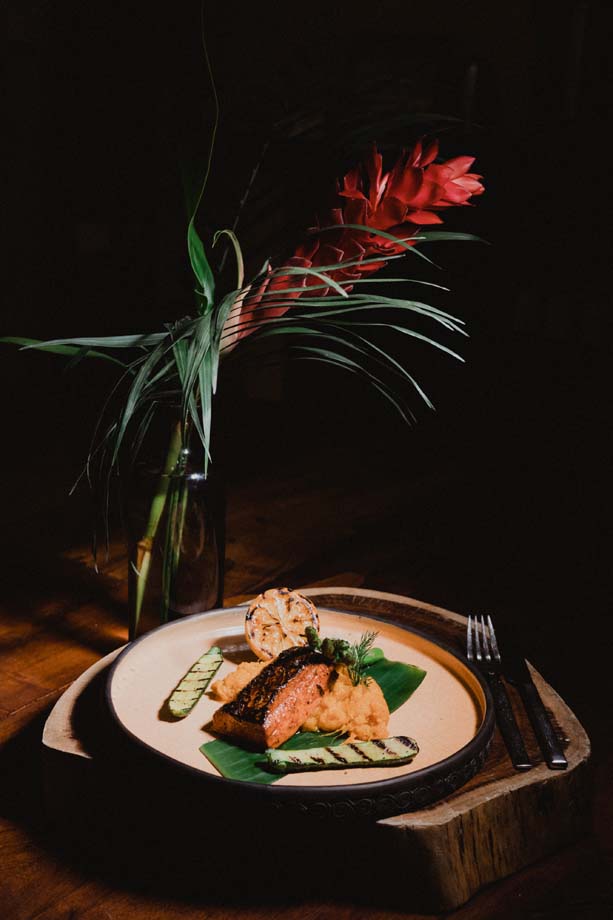 A plated dinner by the hacienda chef, with a tropical flower on the table