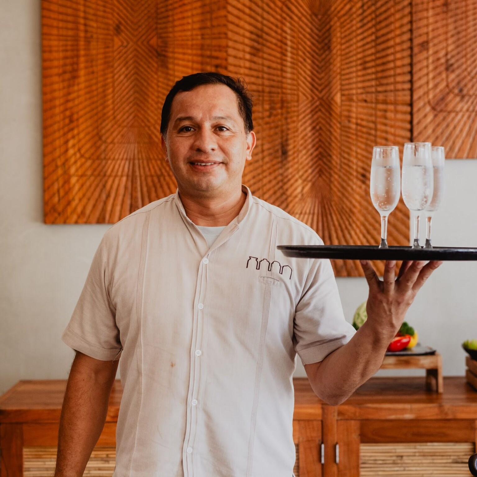 A Hacienda butler carrying a tray of champagne flutes