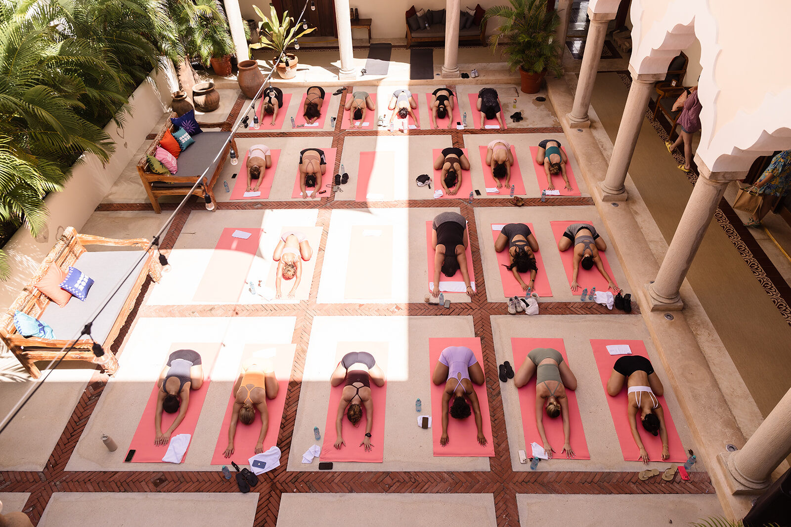 A yoga class on pink mats in the courtyard of Hacienda Corazón, seen from above