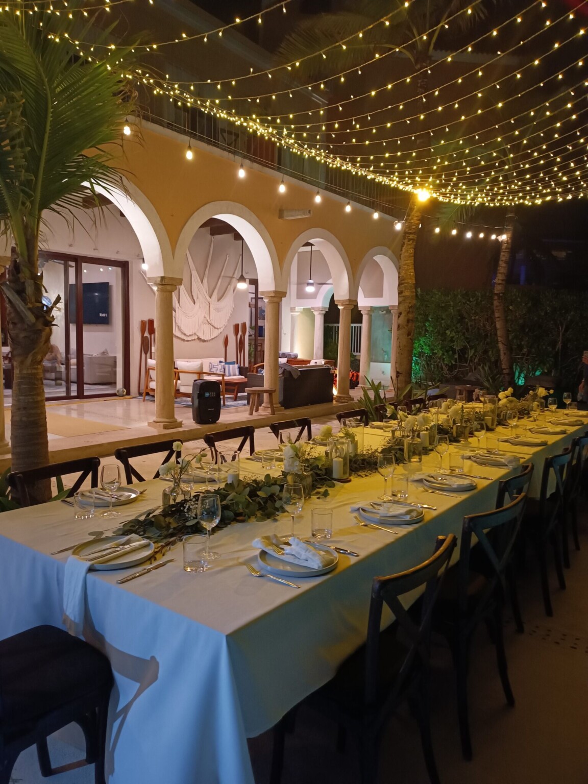 A long dinner table set on the terrace of Hacienda Del Mar under string lights