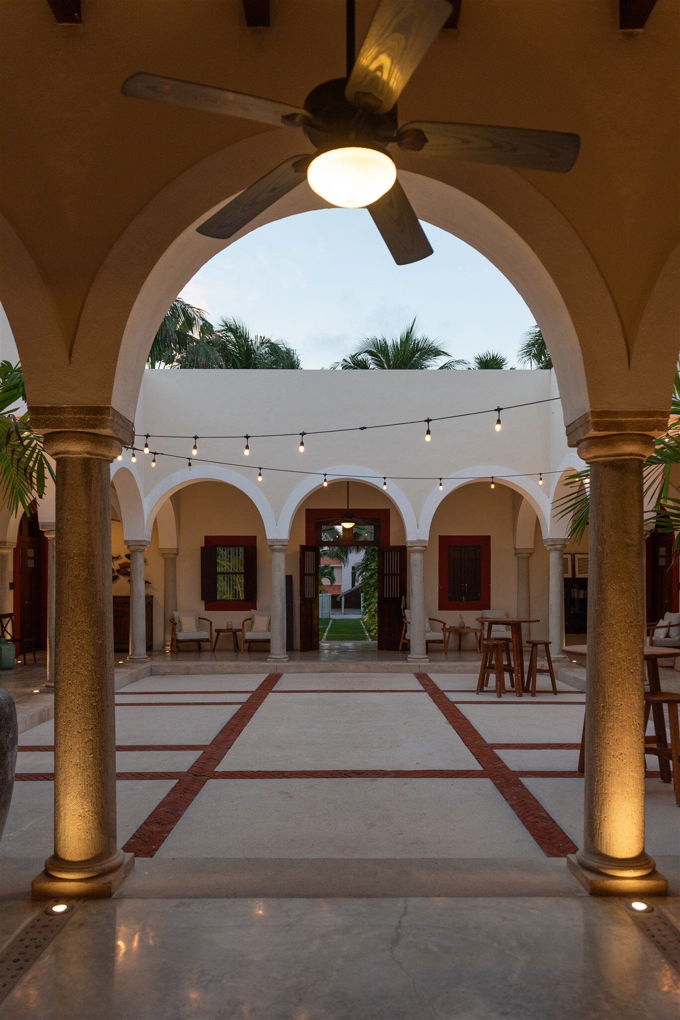 The courtyard of Hacienda Del Mar at dusk, seen through a lit arch
