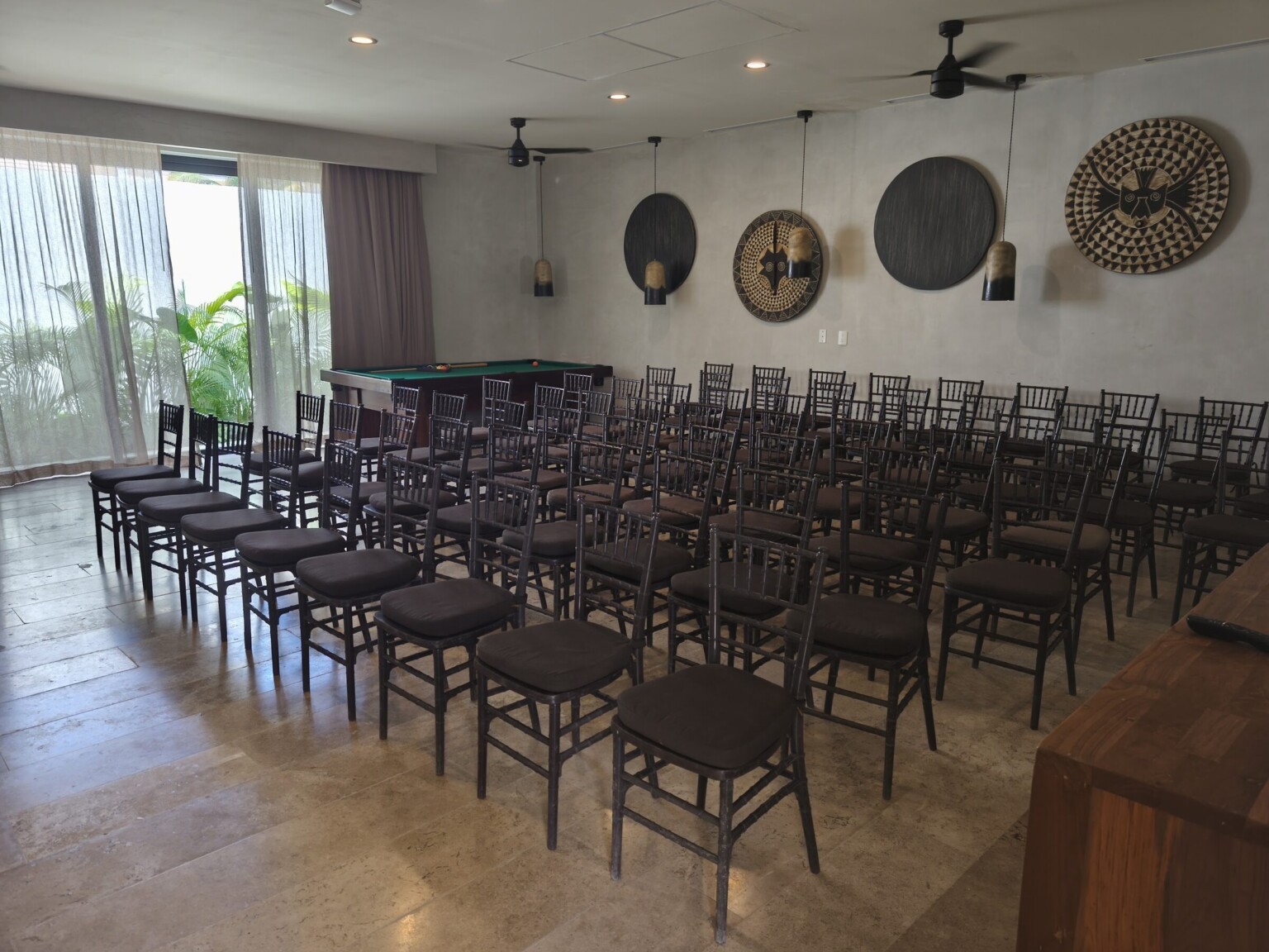 The games room at Hacienda Jaguar in daylight, set theatre-style for 80, garden windows along one side
