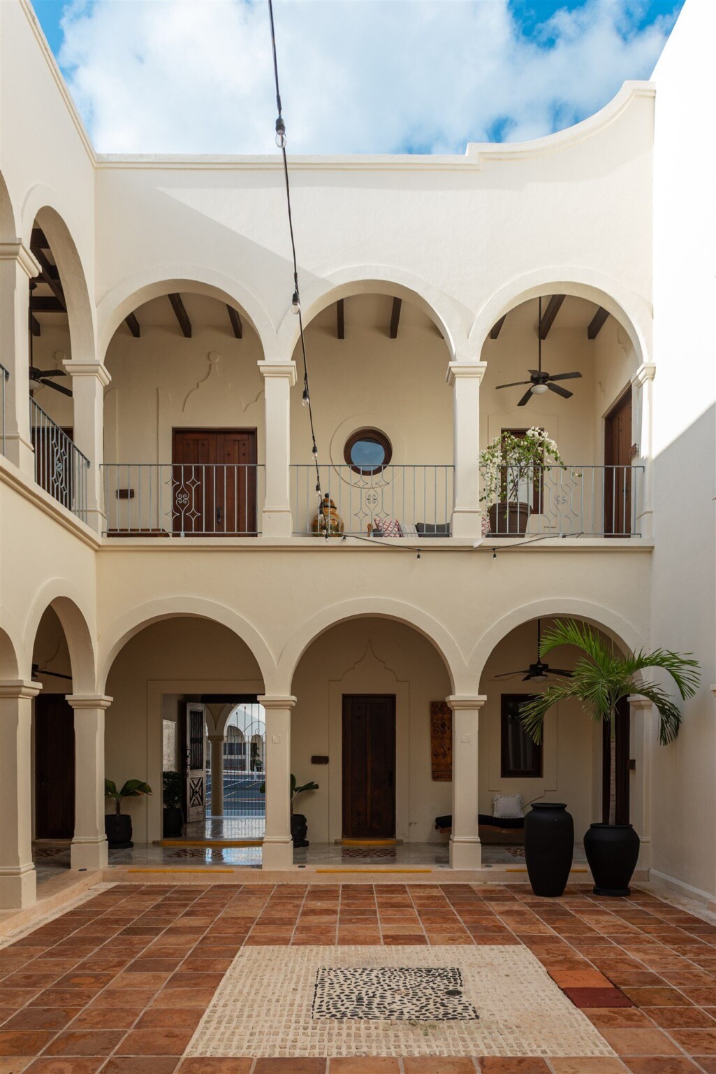 The two-storey arcaded courtyard of Hacienda Mágica, terracotta tiles underfoot