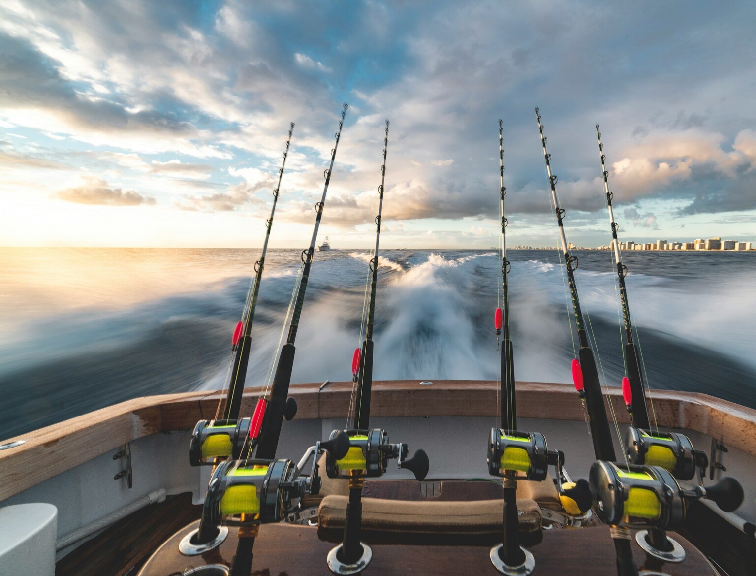Fishing rods off the stern of a sport-fishing boat at sunrise