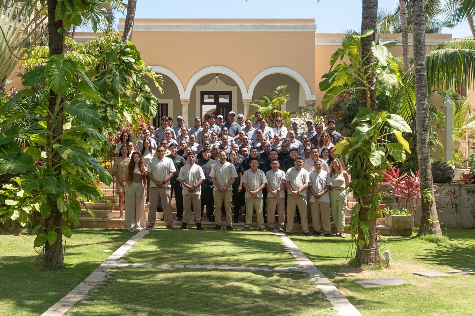The Riviera Maya Haciendas team in uniform, gathered on the steps of a hacienda