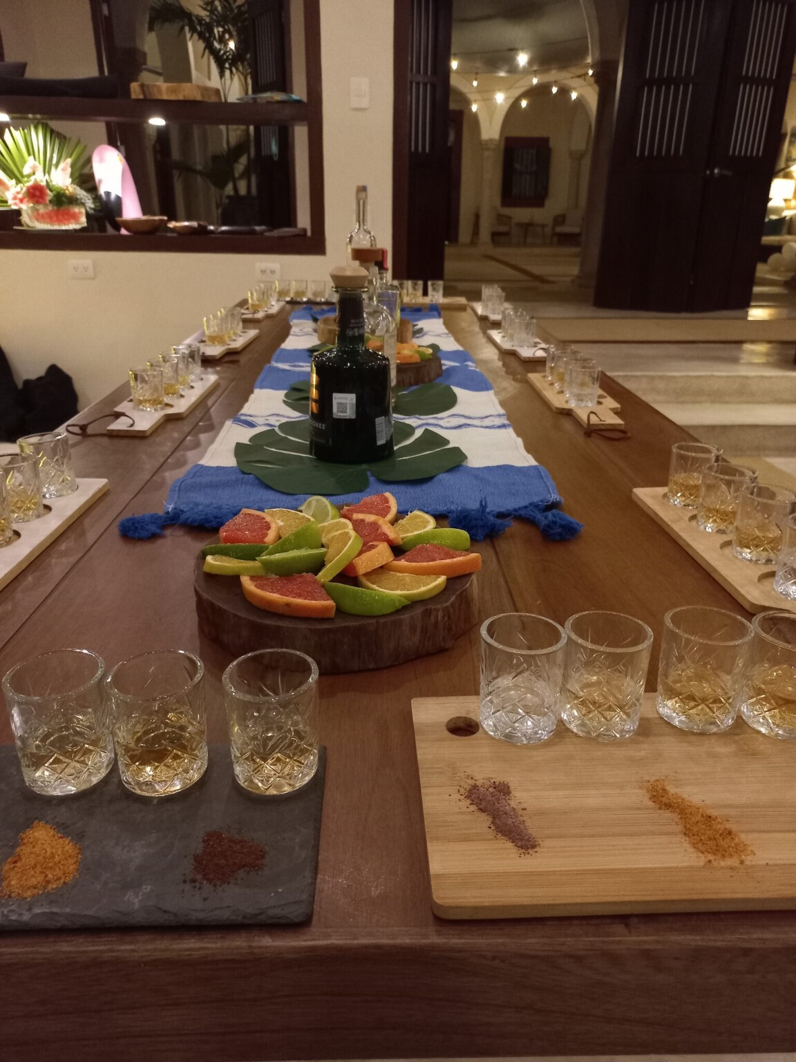 Tequila tasting glasses on slate and wood boards with citrus, arches behind