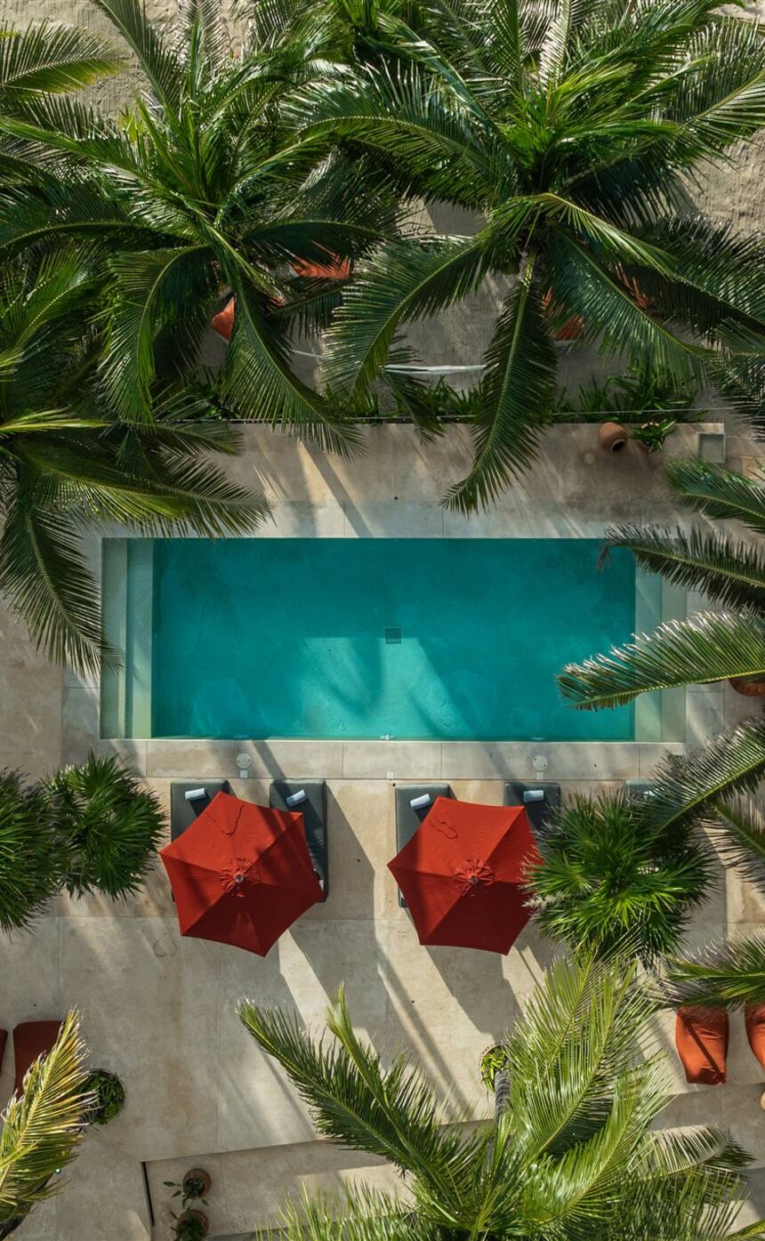 Hacienda Corazón from above: the pool, red umbrellas and palms