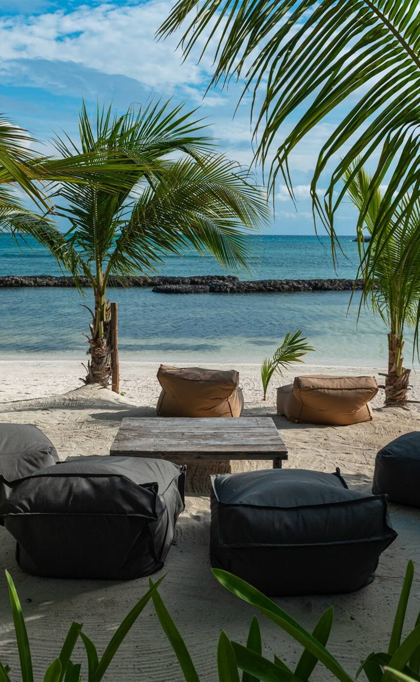 Lounges on the sand in front of Hacienda Mágica