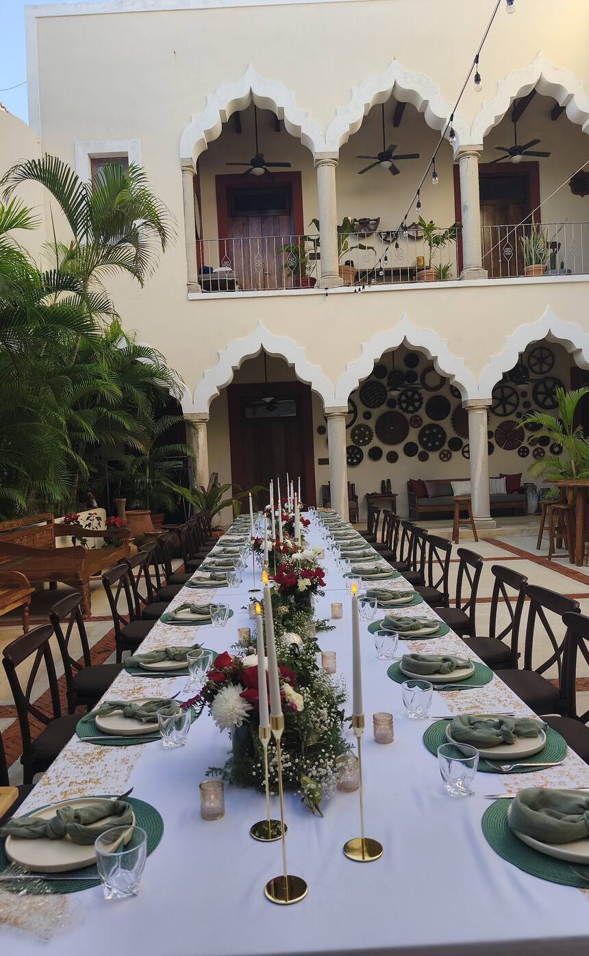 A candlelit long table in the scalloped-arch courtyard of Hacienda Corazón