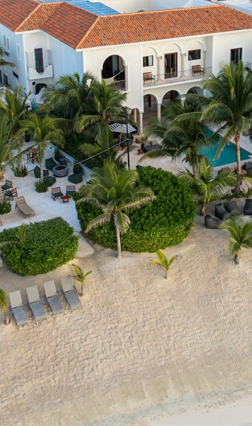 The haciendas from the beach in Puerto Aventuras: white façades, arches, pools and palms